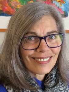 head and shoulders image of a smiling woman with glasses and silver hair in her sixties